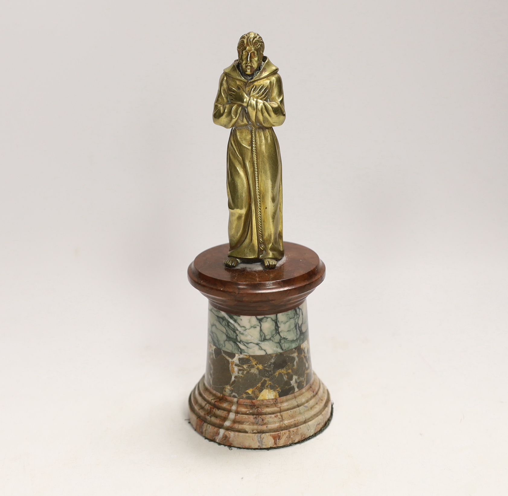A 19th century gilt bronze of a monk on a specimen marble base, comprising four different marble strata, 20cm